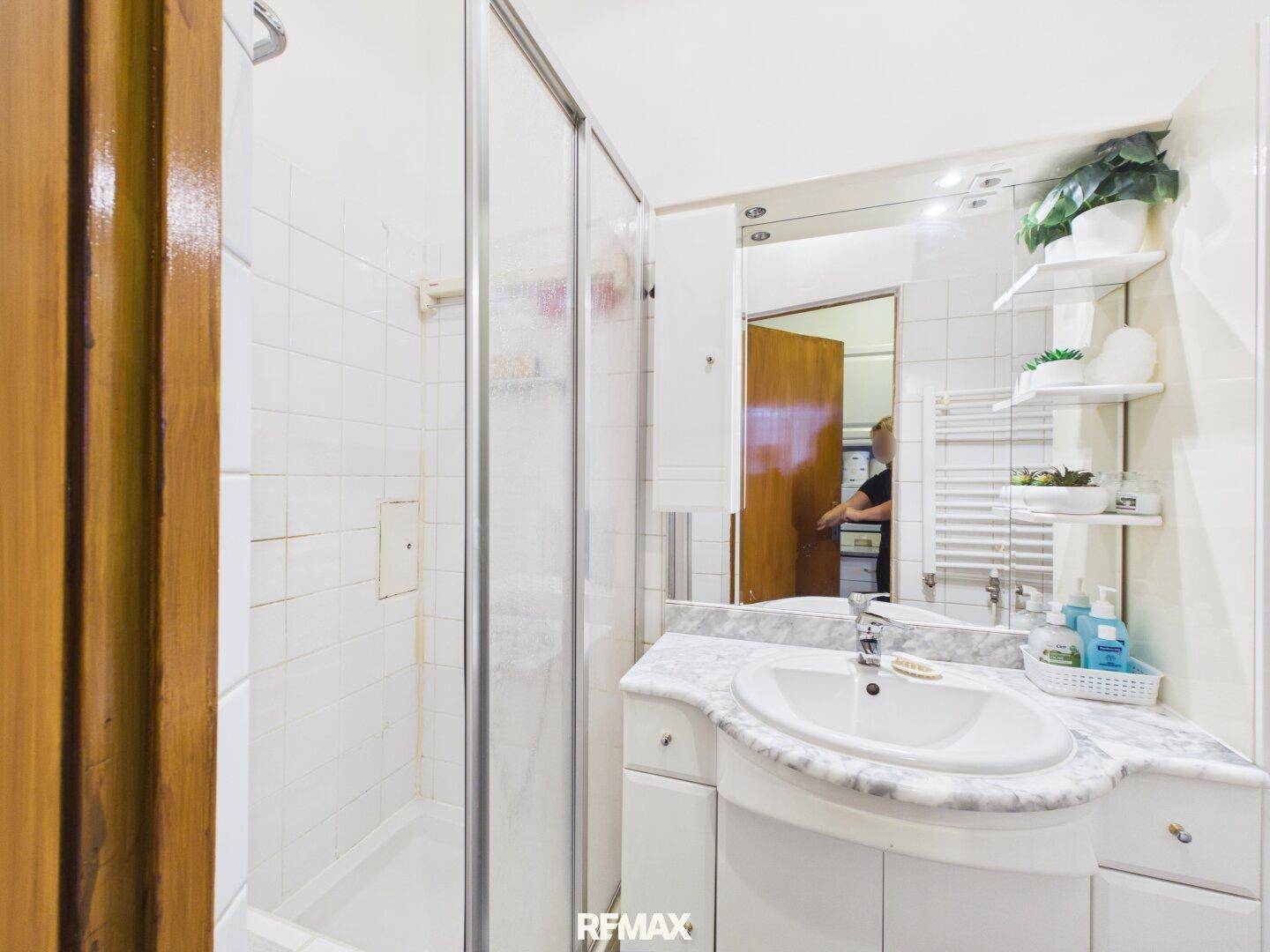 Badezimmer mit Duschkabine, Einzelwaschbecken und Spiegelschrank für den täglichen Komfort.