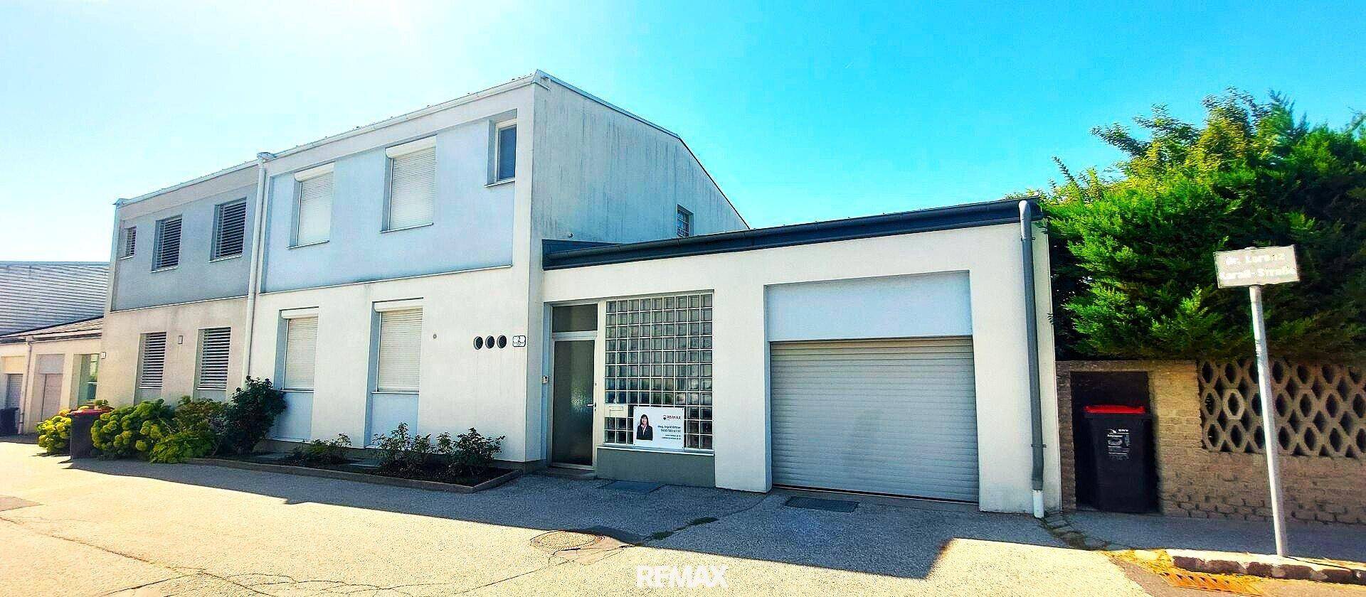 Vorderansicht des Hauses mit Garage, Einfahrt und einem kleinen Vorgartenbereich.