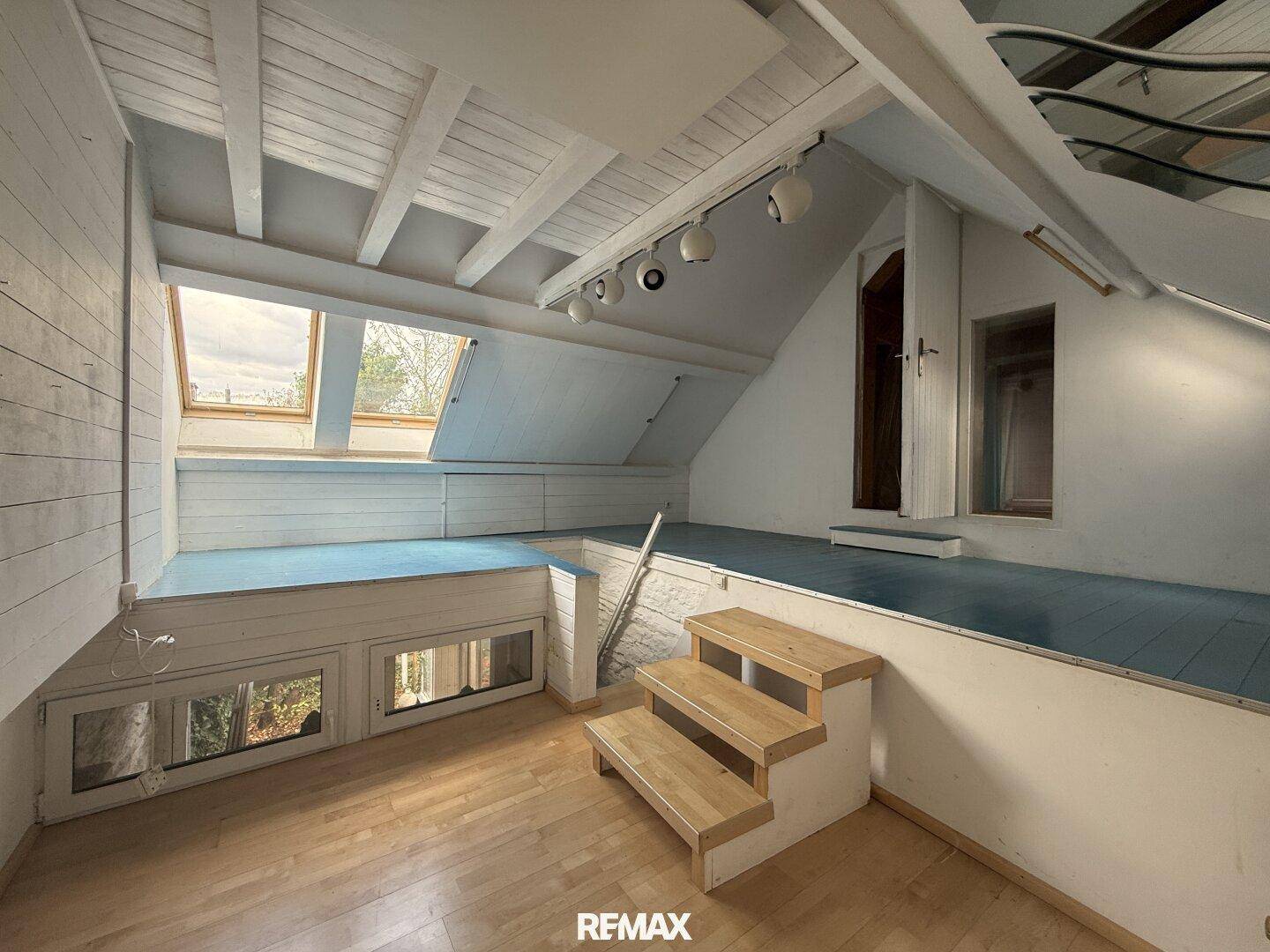 Heller Dachboden mit mehreren Ebenen, Dachfenstern und Holzboden, ideal für kreative Nutzung.