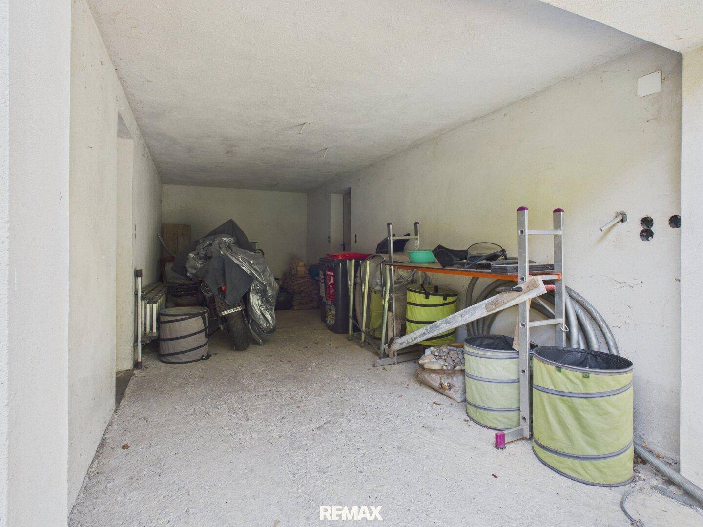 Geräumige Garage oder Abstellraum im Untergeschoss mit Betonboden und Lagerflächen.