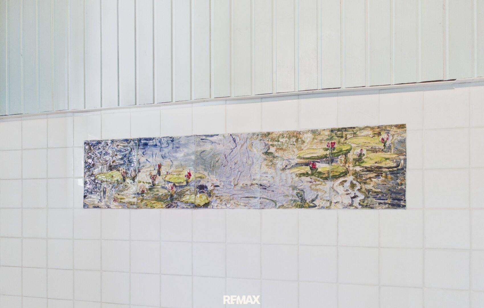 Detailansicht der Wandfliesen im Badezimmer mit dekorativem Bildmotiv.