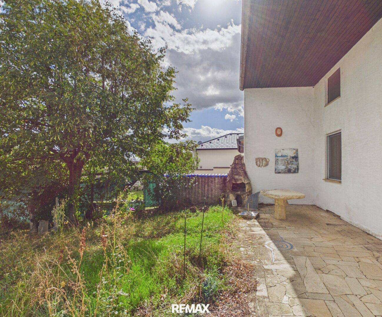Gartenbereich mit Terrasse, Grillplatz und altem Baumbestand, ideal für Entspannung.