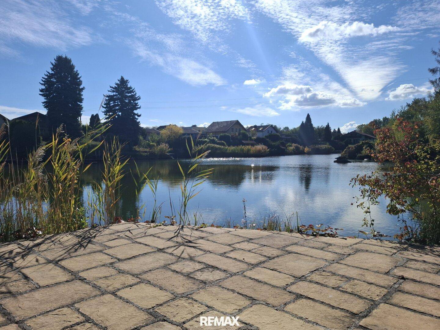 Weitläufige Terrasse mit direktem Blick auf den ruhigen See und die umliegende Natur.
