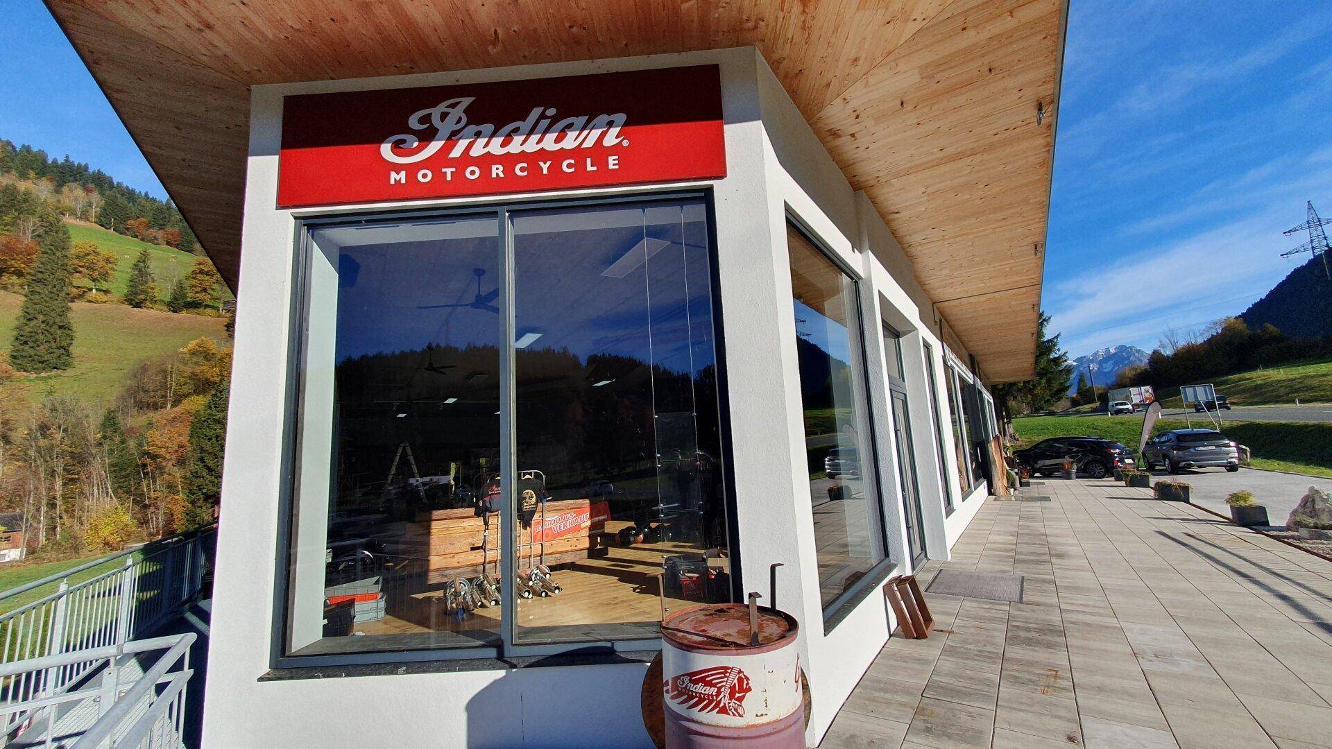 Detailansicht der modernen Fassade mit großen Glasflächen und Holzelementen, die das Innere des Geschäfts zeigen.