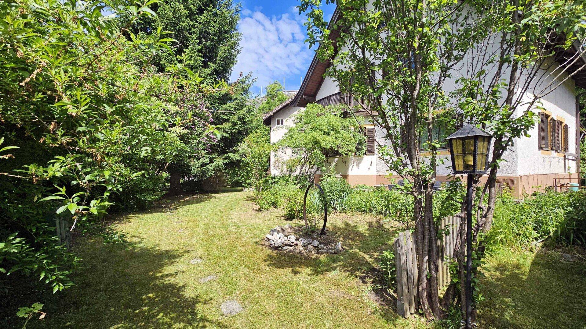 Garten mit traditioneller Außenlaterne und dem seitlichen Blick auf das Wohngebäude.