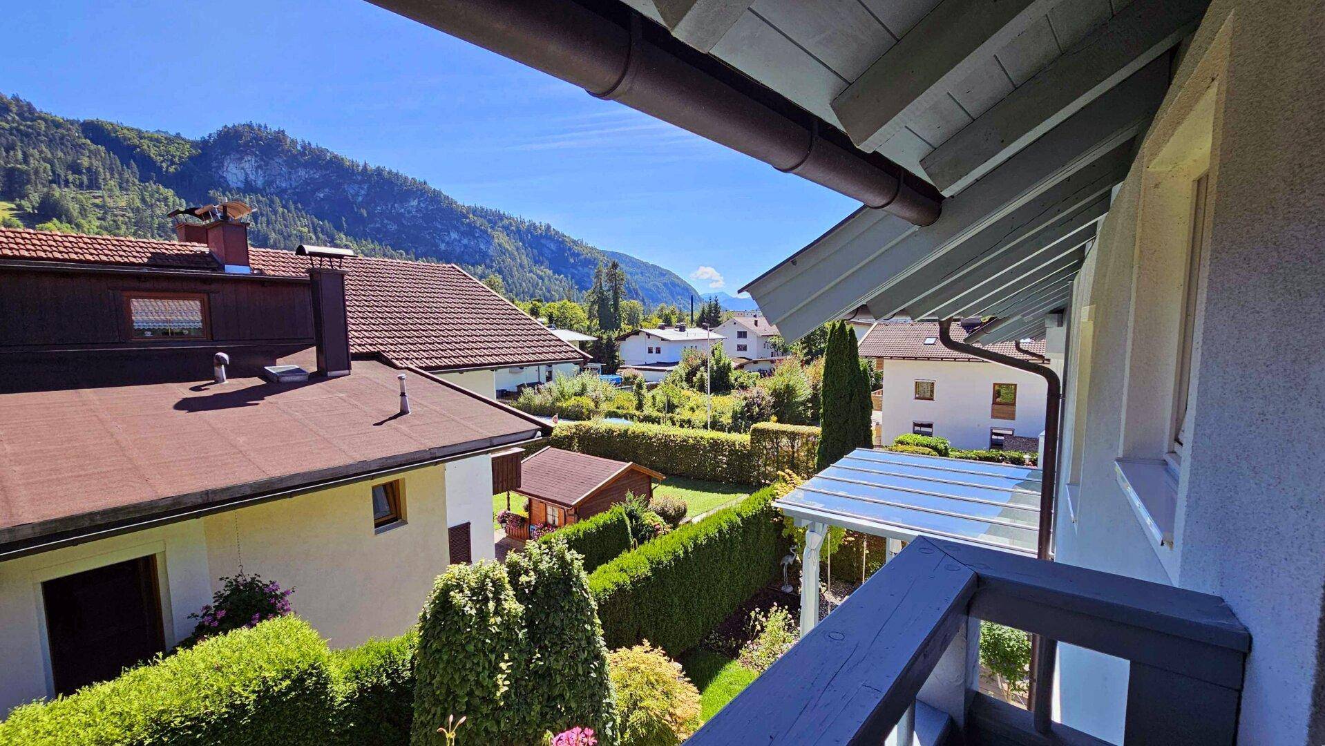 Balkon mit Bergblick und grüner Umgebung, ideal für entspannte Stunden im Freien.