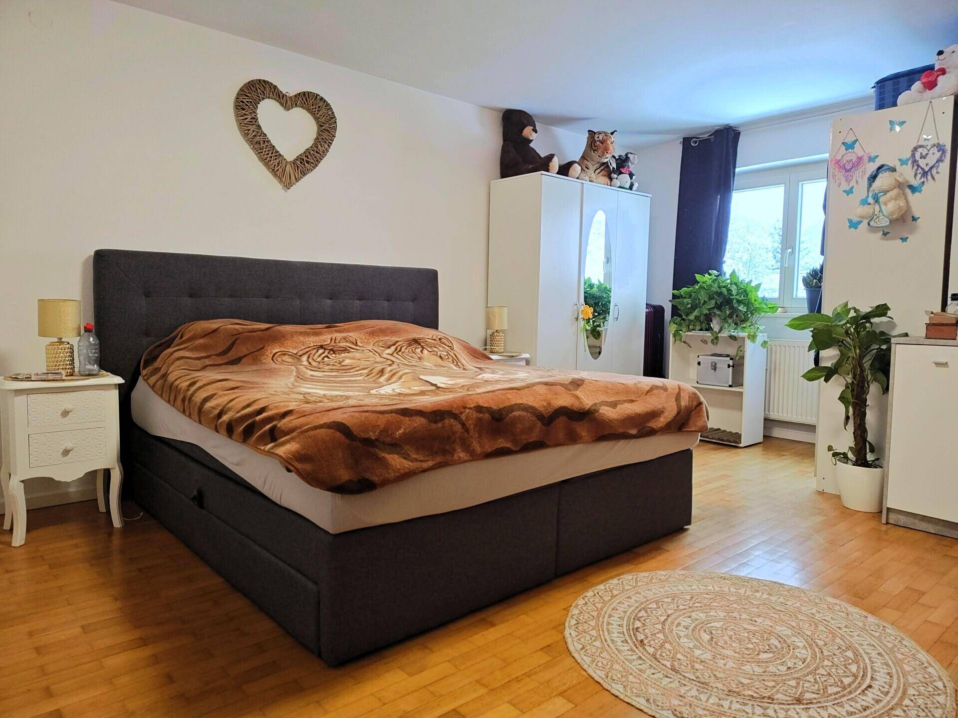 Geräumiges Schlafzimmer mit großem Bett, Kleiderschrank und Holzboden.