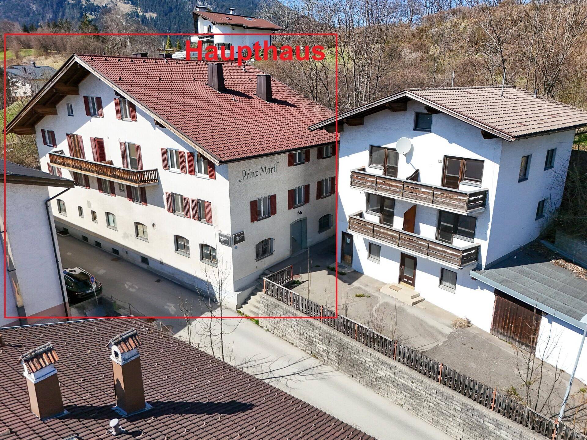 Luftaufnahme des Haupthauses mit traditioneller Architektur und roten Fensterläden.