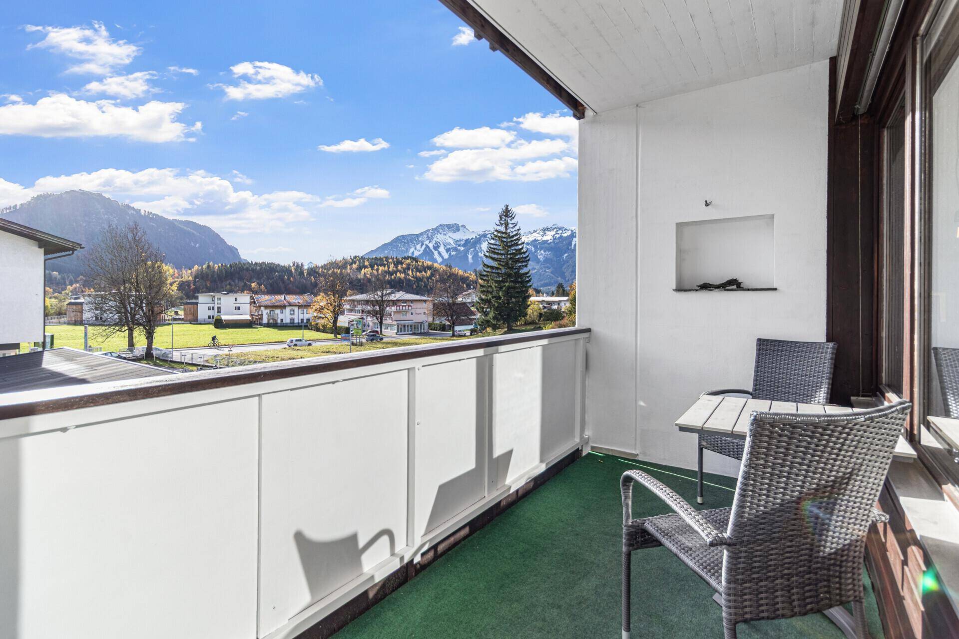 Geräumiger Balkon mit Sitzgelegenheiten und einem atemberaubenden Panoramablick auf die umliegende Berglandschaft.