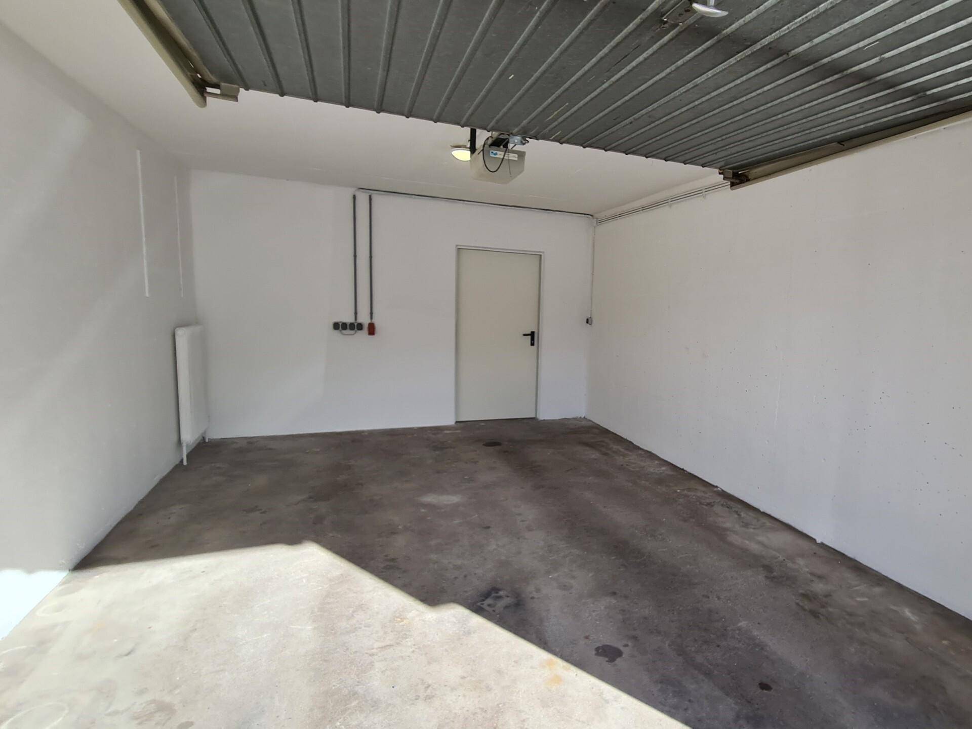 Geräumige und saubere Garage mit Betonboden, ideal für ein Fahrzeug oder als zusätzlicher Stauraum.