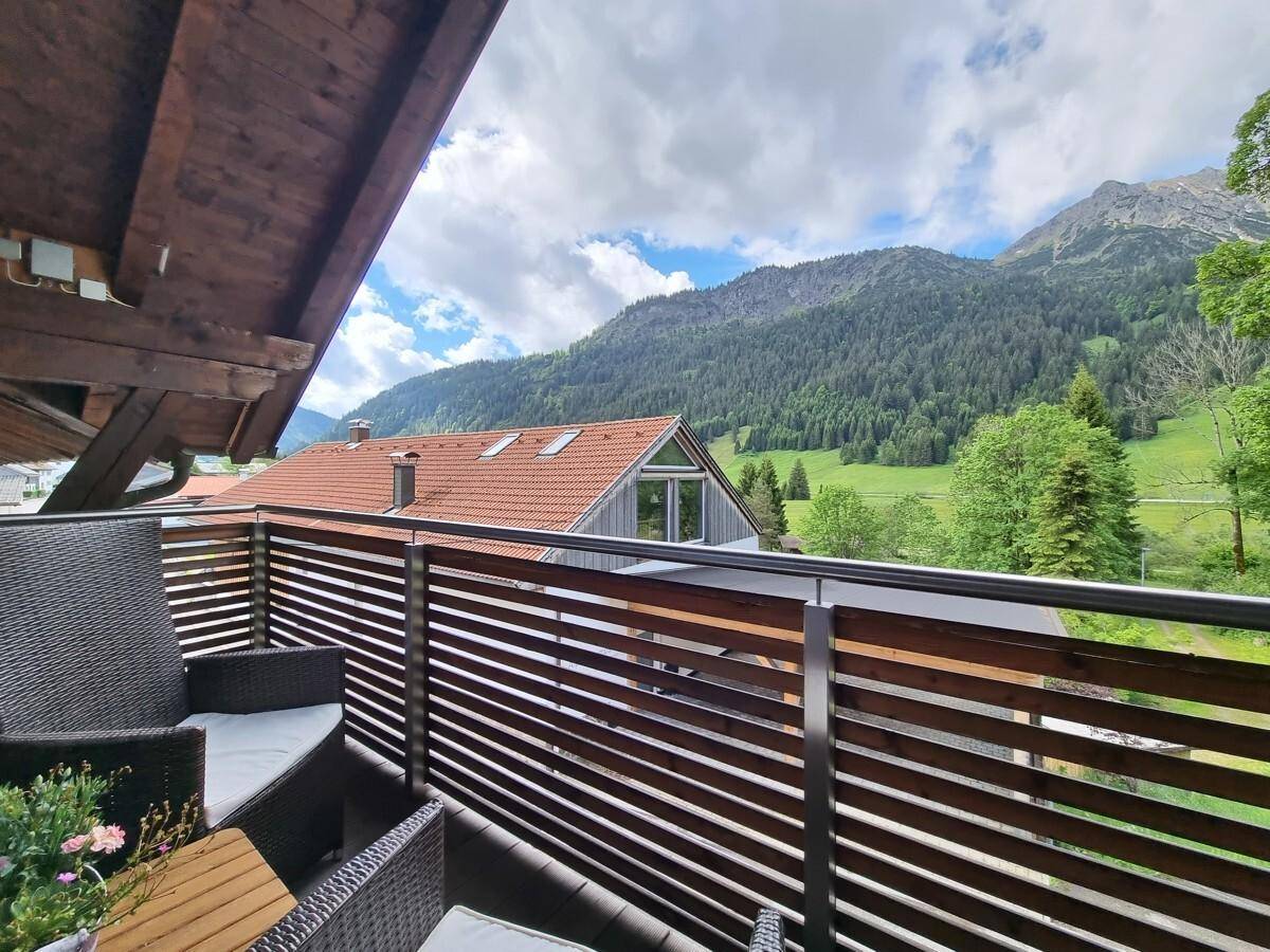 Gemütlicher Balkon mit Sitzgelegenheiten und weitem Blick auf die umliegende Berglandschaft.