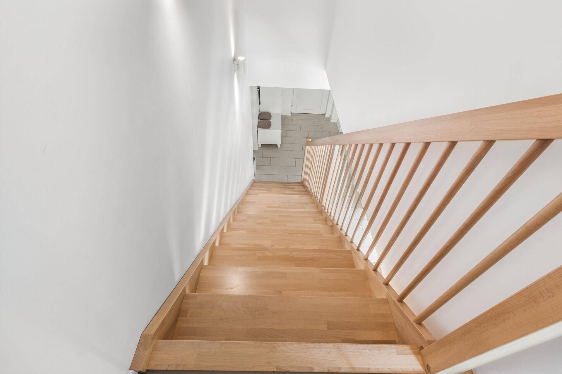 Holztreppe führt vom Obergeschoss in den unteren Bereich des Hauses.