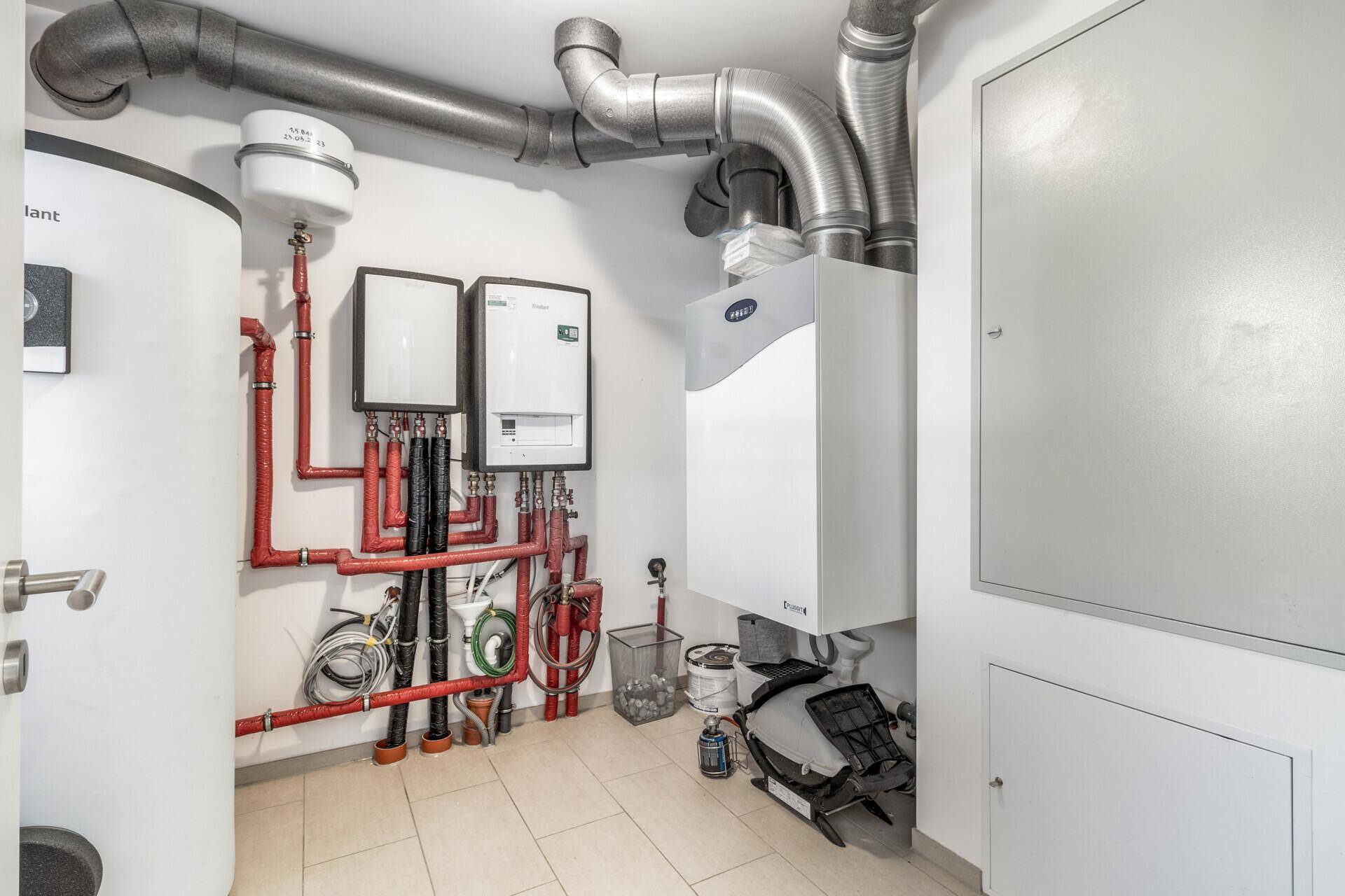 Technikraum mit Heizungsanlage, Warmwasserspeicher und Lüftungssystem.