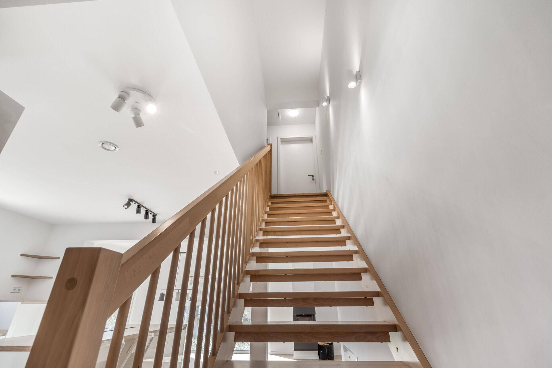 Helle Holztreppe führt in das obere Stockwerk des Hauses.
