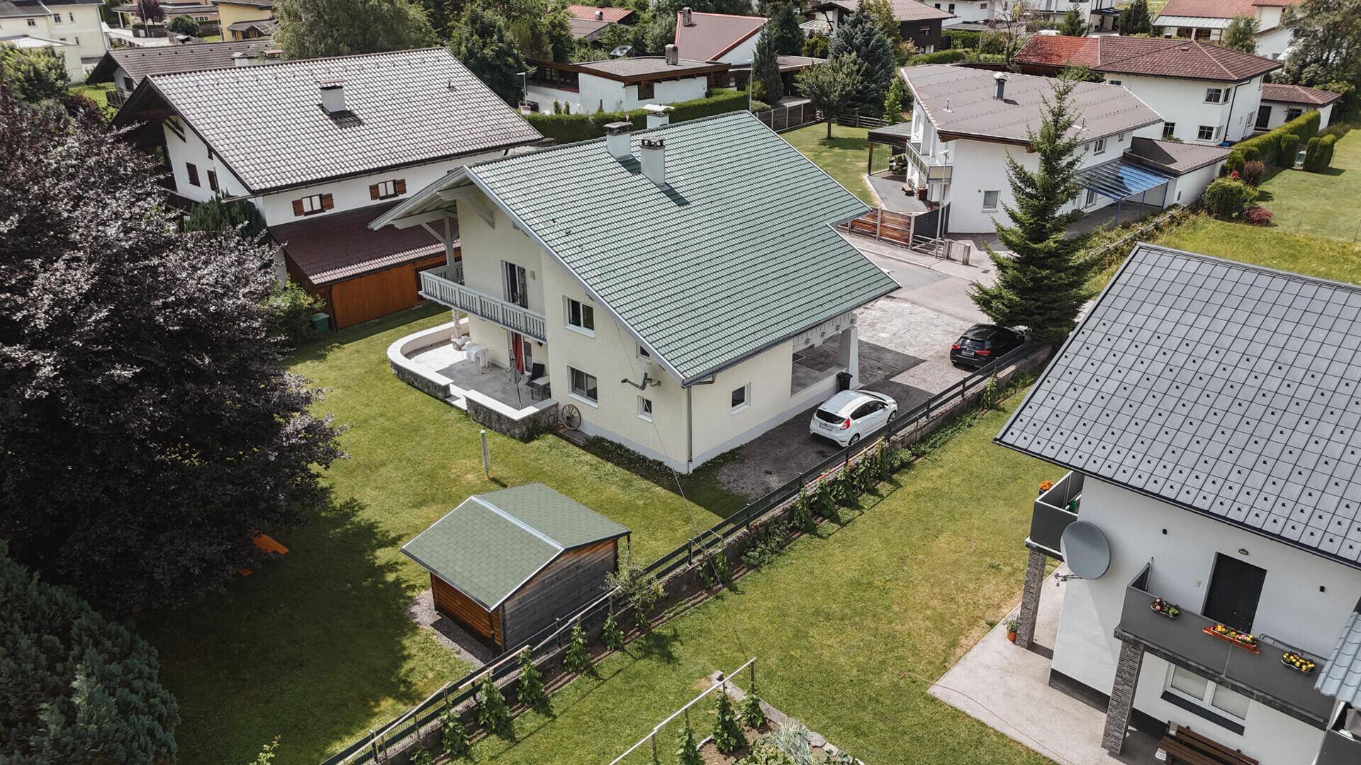 Vogelperspektive des Hauses mit gepflegtem Garten, Gartenhaus und Solaranlage auf dem Dach.
