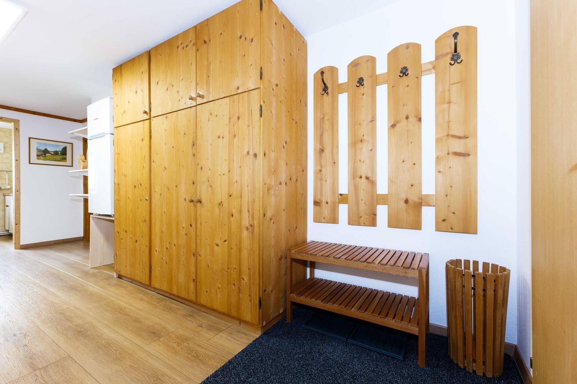 Einladender Flur mit Holzmöbeln, Garderobe und viel Stauraum.
