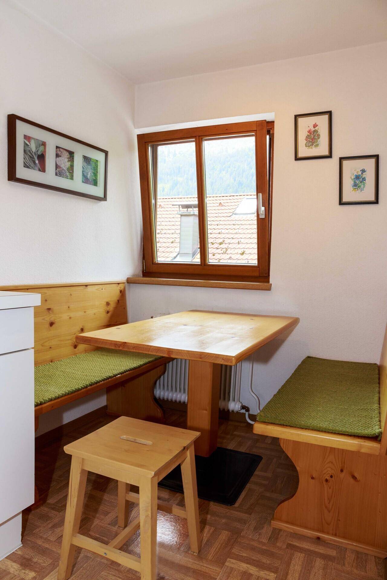Gemütlicher Essbereich in der Küchenzeile mit Holztisch und Sitzbänken.