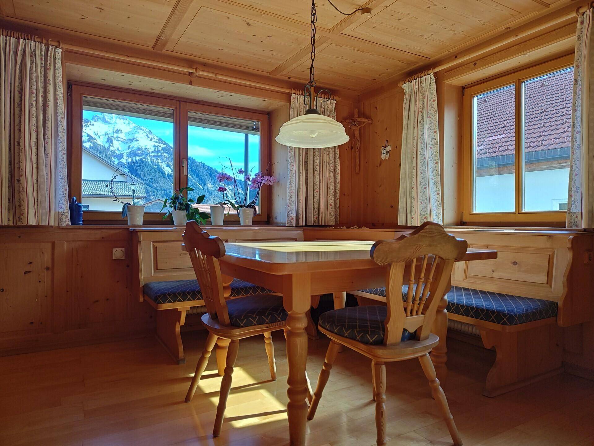 Traditioneller Essbereich im alpinen Stil mit Holzvertäfelung und Bergblick.