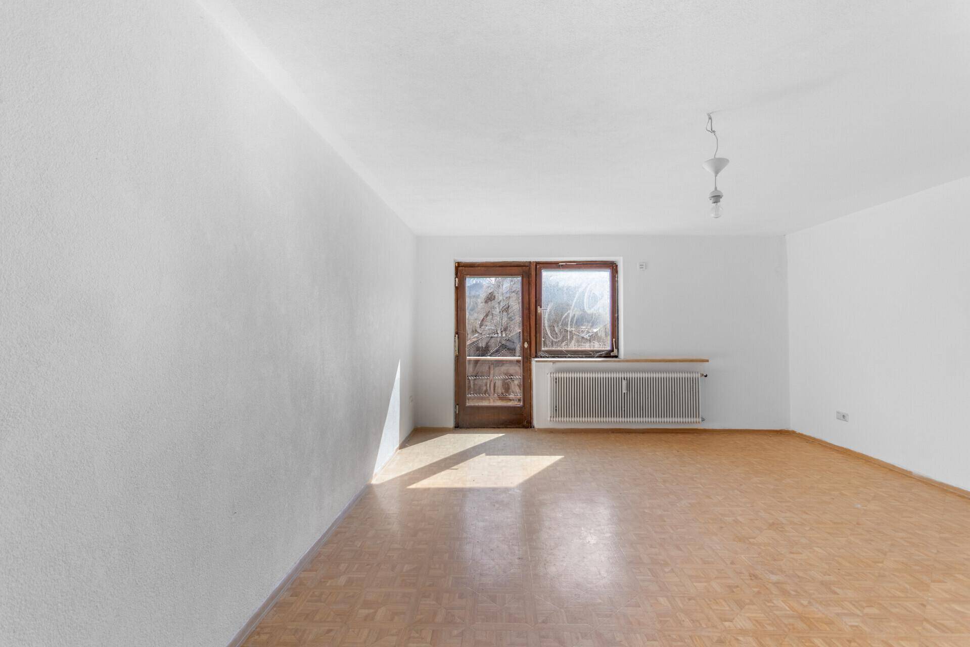 Heller Wohnraum mit Laminatboden und direktem Zugang zu einem Balkon.