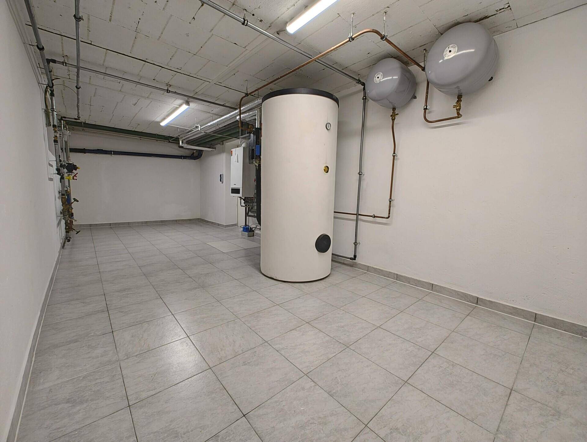 Geräumiger Technikraum im Keller mit Heizungsanlage und Fliesenboden.