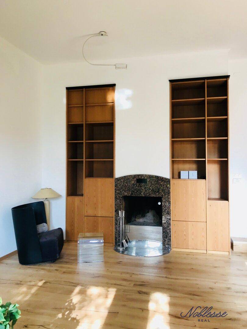 Wohnzimmer mit elegantem Kamin und integrierten Holzregalen, schafft eine warme Atmosphäre.
