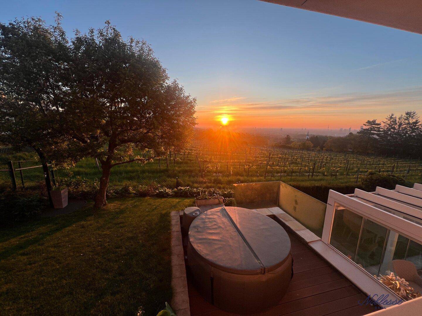 Terrasse mit Whirlpool und atemberaubendem Sonnenuntergang über den Weinbergen.