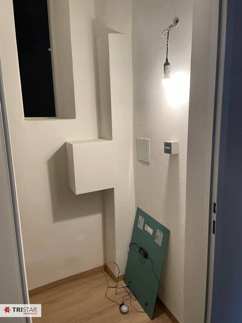 Ecke mit elektrischem Verteilerkasten und provisorischer Beleuchtung während der Bauphase.