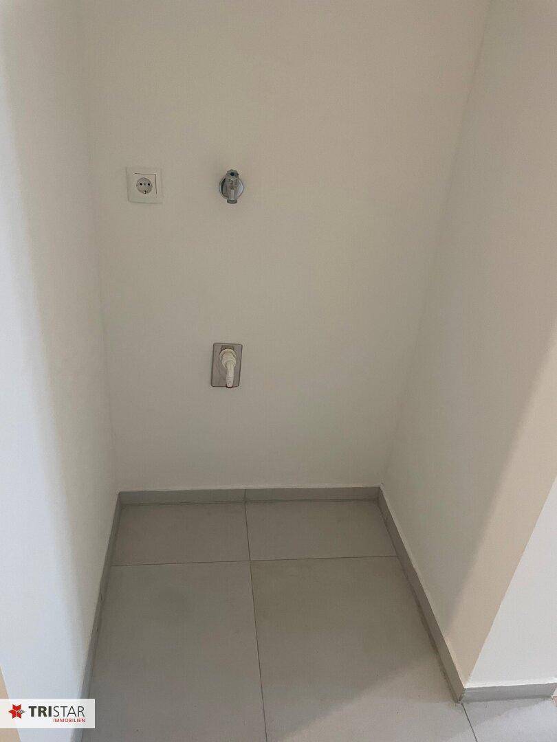 Kleiner Hauswirtschaftsraum mit Anschlüssen für Waschmaschine und Trockner.