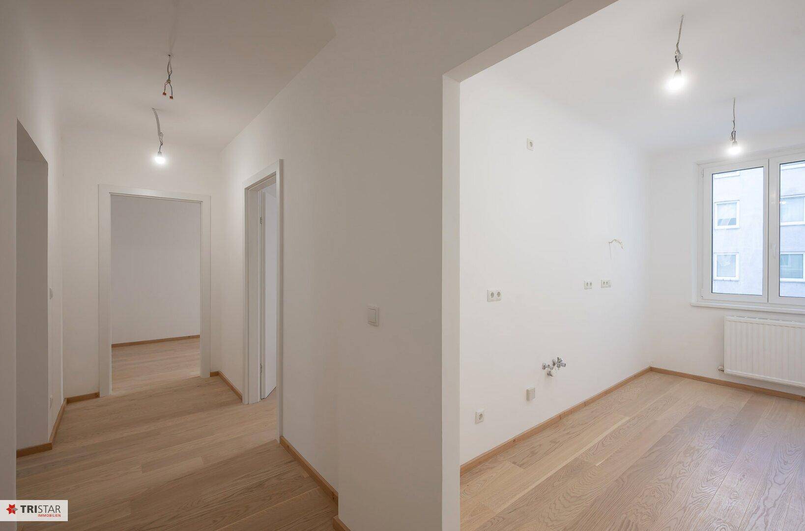 Lichtdurchfluteter Raum mit Parkettboden und großen Fenstern, bereit zur individuellen Gestaltung.