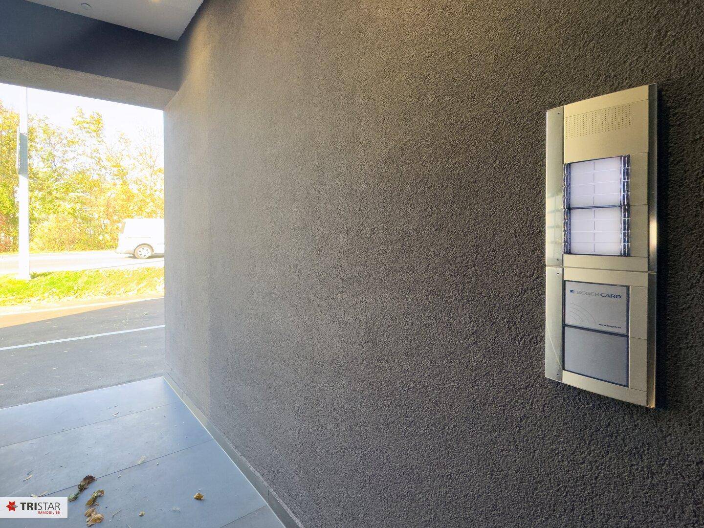 Eingangsbereich mit modernem Zugangssystem und strukturierter Fassade.