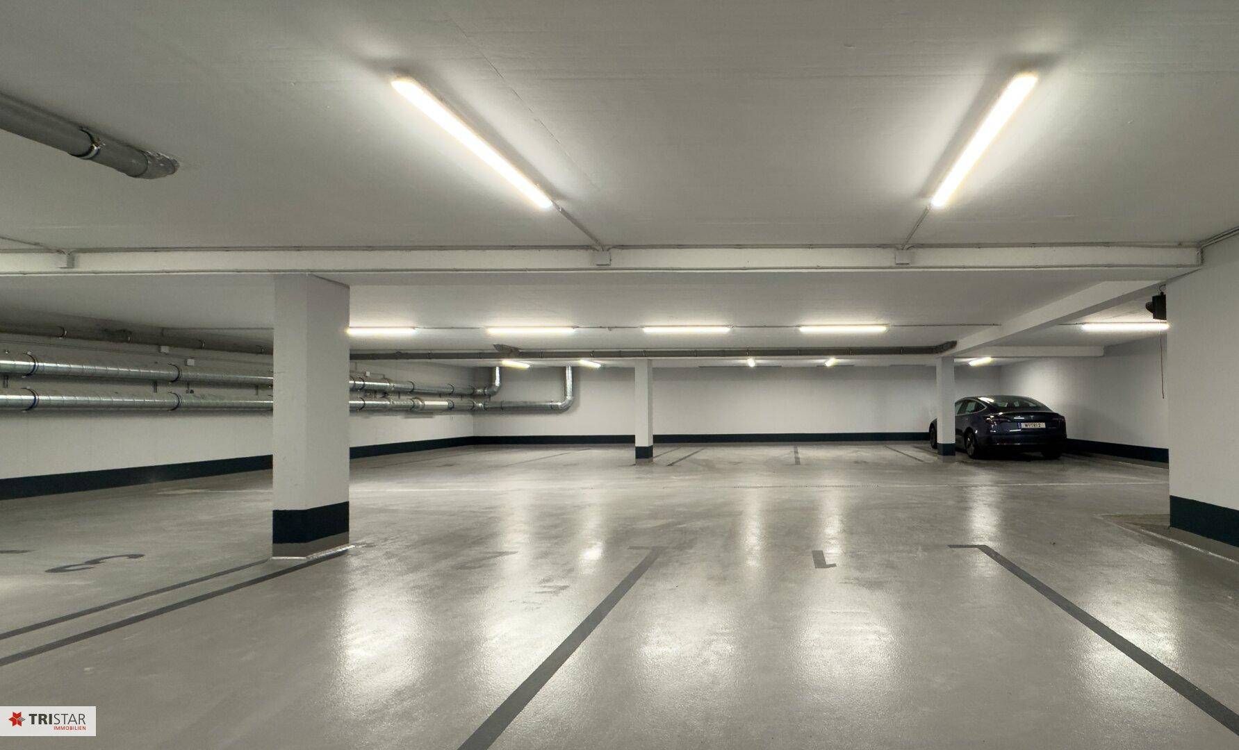 Geräumige Tiefgarage mit markierten Stellplätzen und guter Beleuchtung.
