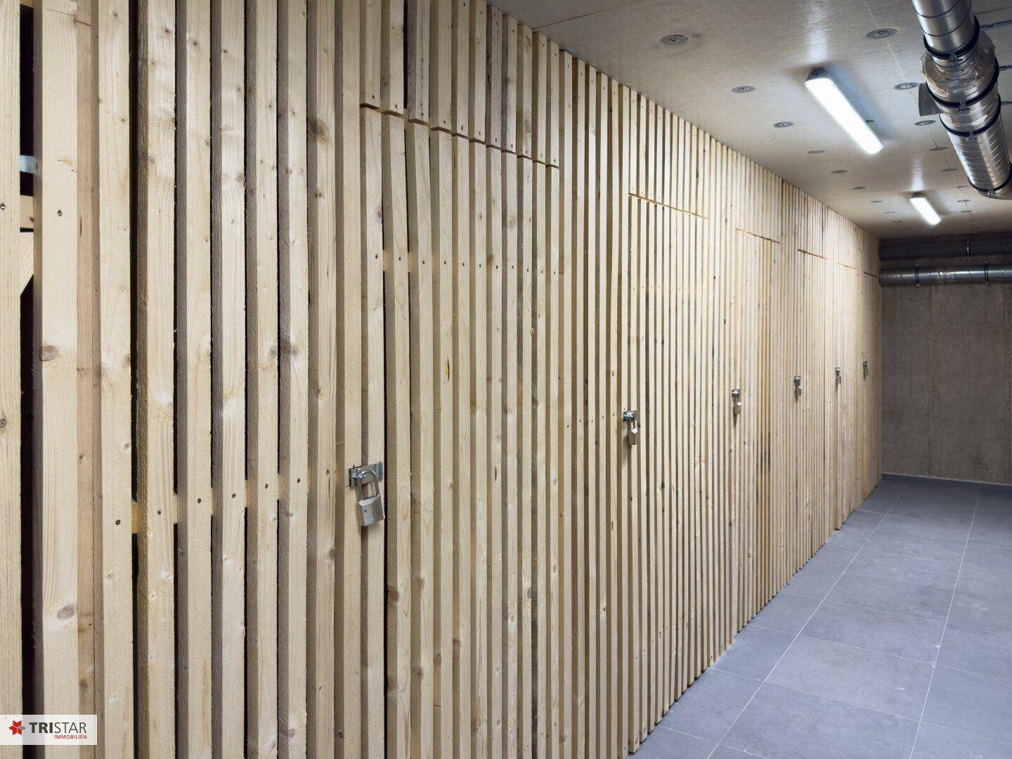 Abstellraum im Keller mit individuellen Holzverschlägen für zusätzlichen Stauraum.