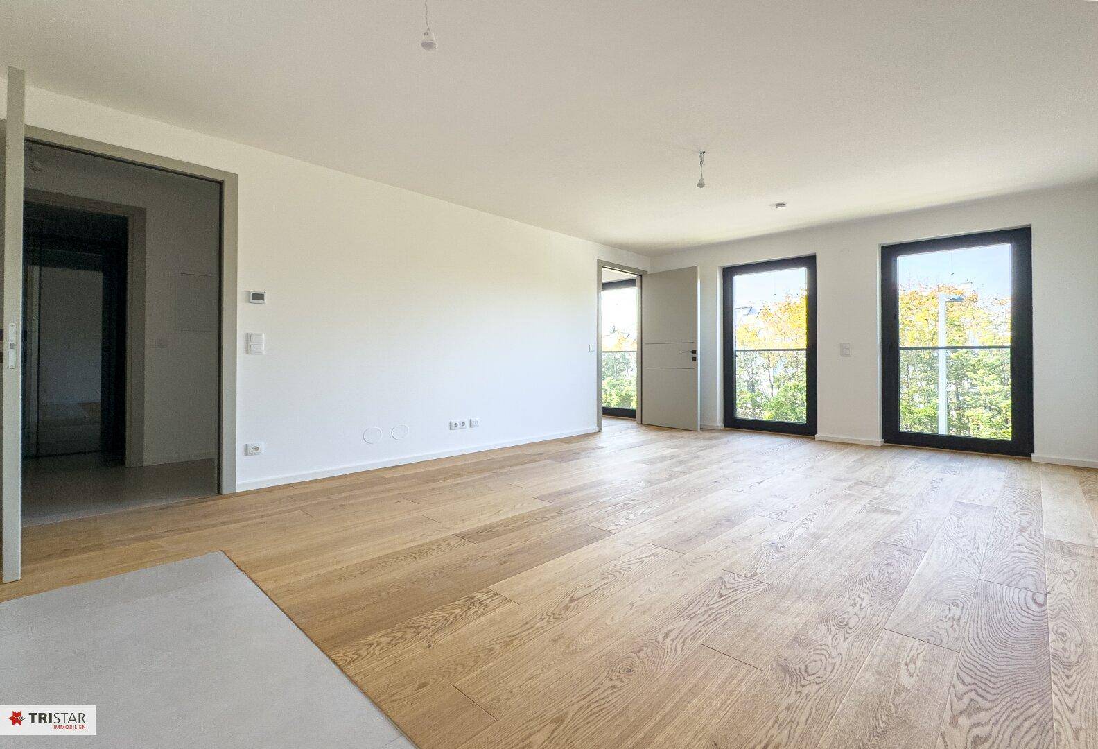 Großzügiger, heller Raum mit Holzboden und mehreren Fenstern für optimale Belichtung.