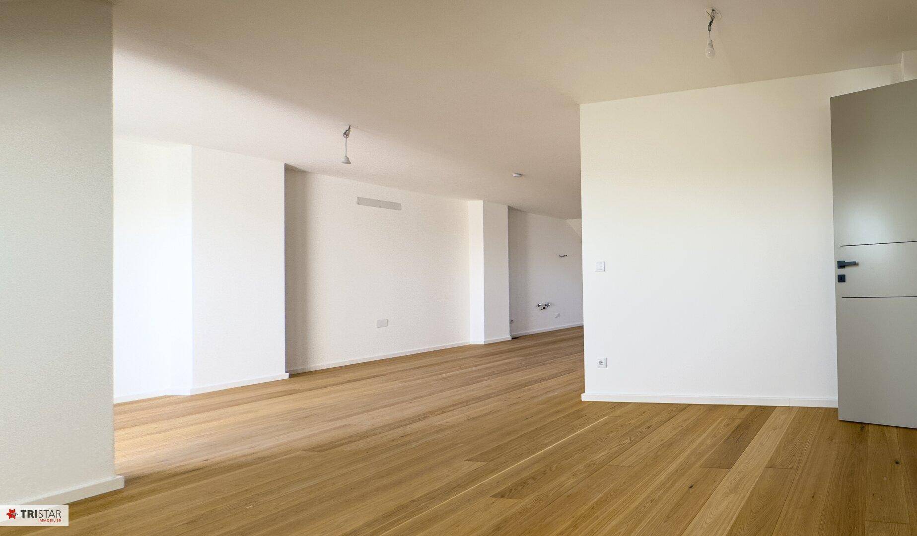 Langer, heller Flur mit Holzboden, der zu weiteren Räumen führt, in modernem Design.