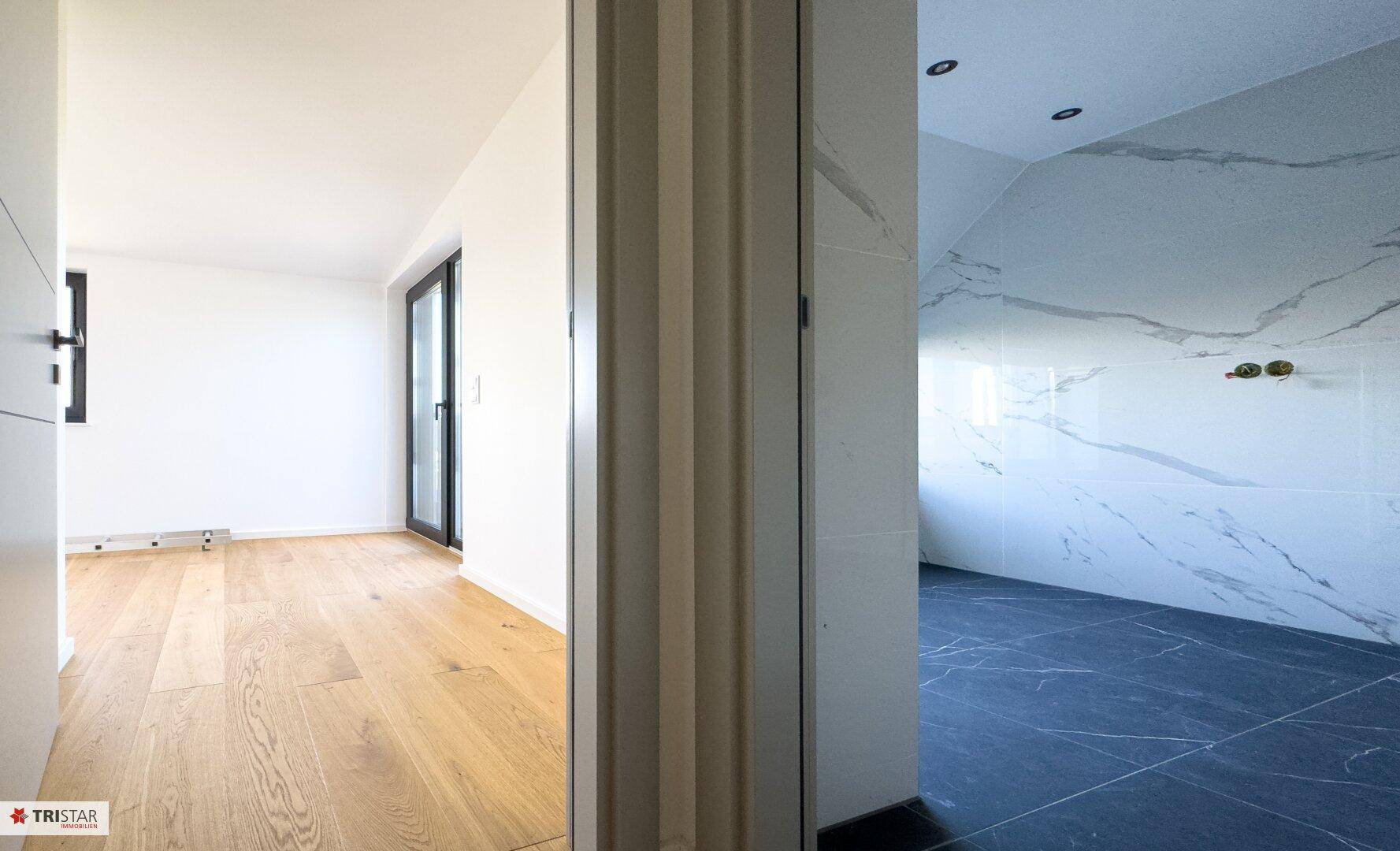 Heller Übergangsbereich mit Holzboden, der zu einem modernen Badezimmer führt.