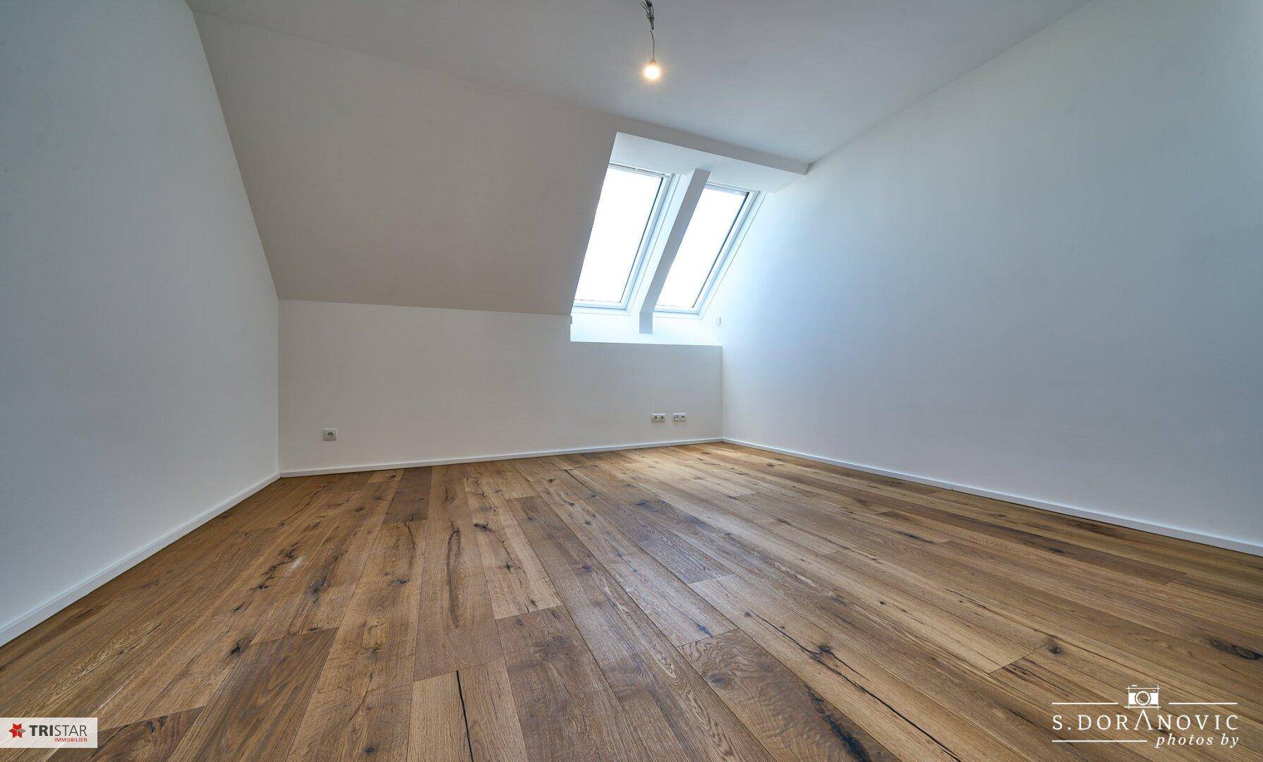 Ruhiger Dachgeschossraum mit Holzboden und Oberlicht, ideal als Schlafzimmer oder Arbeitszimmer.
