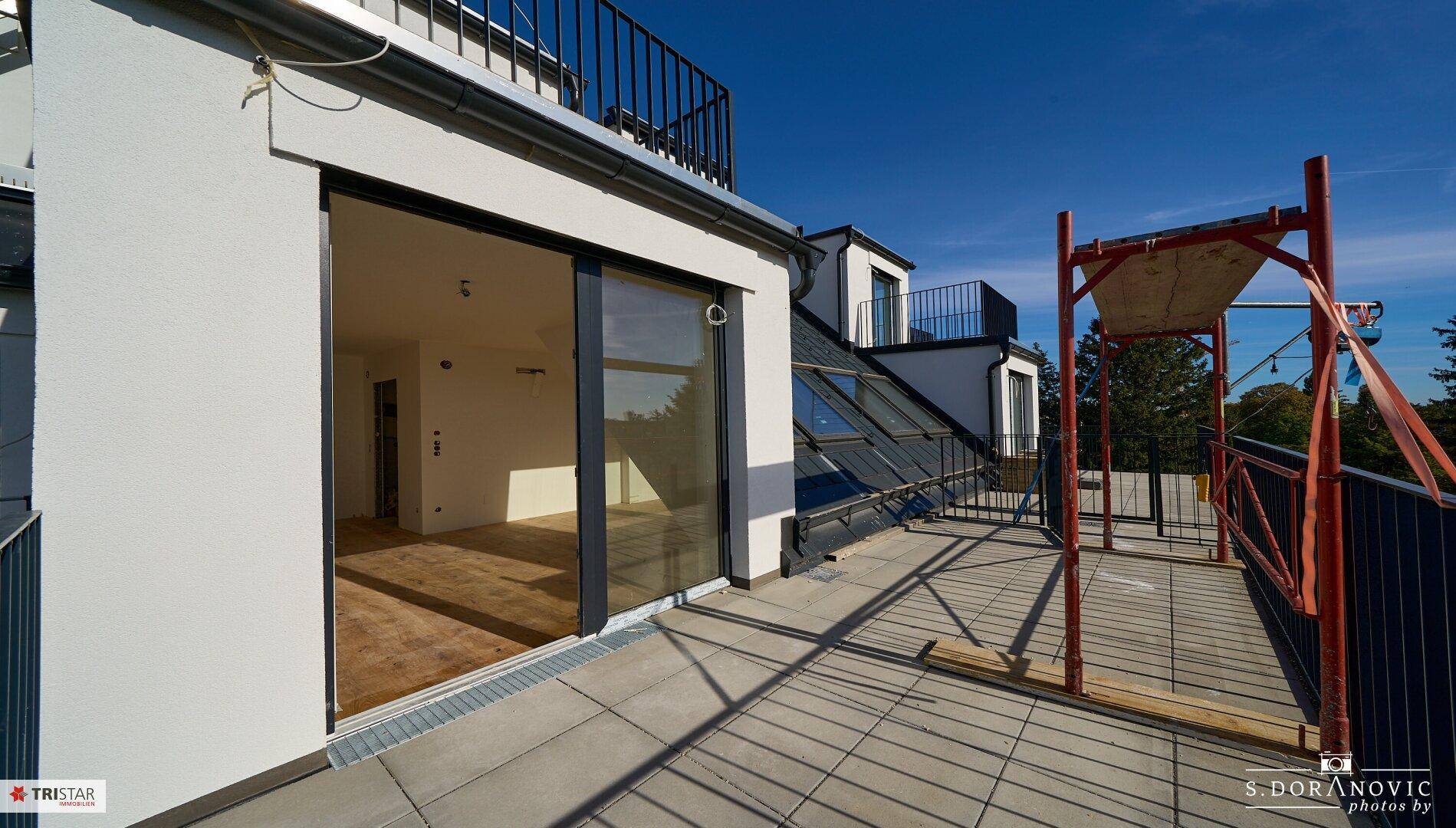 Geräumige Terrasse mit Blick auf die Umgebung und Zugang zum Innenbereich.