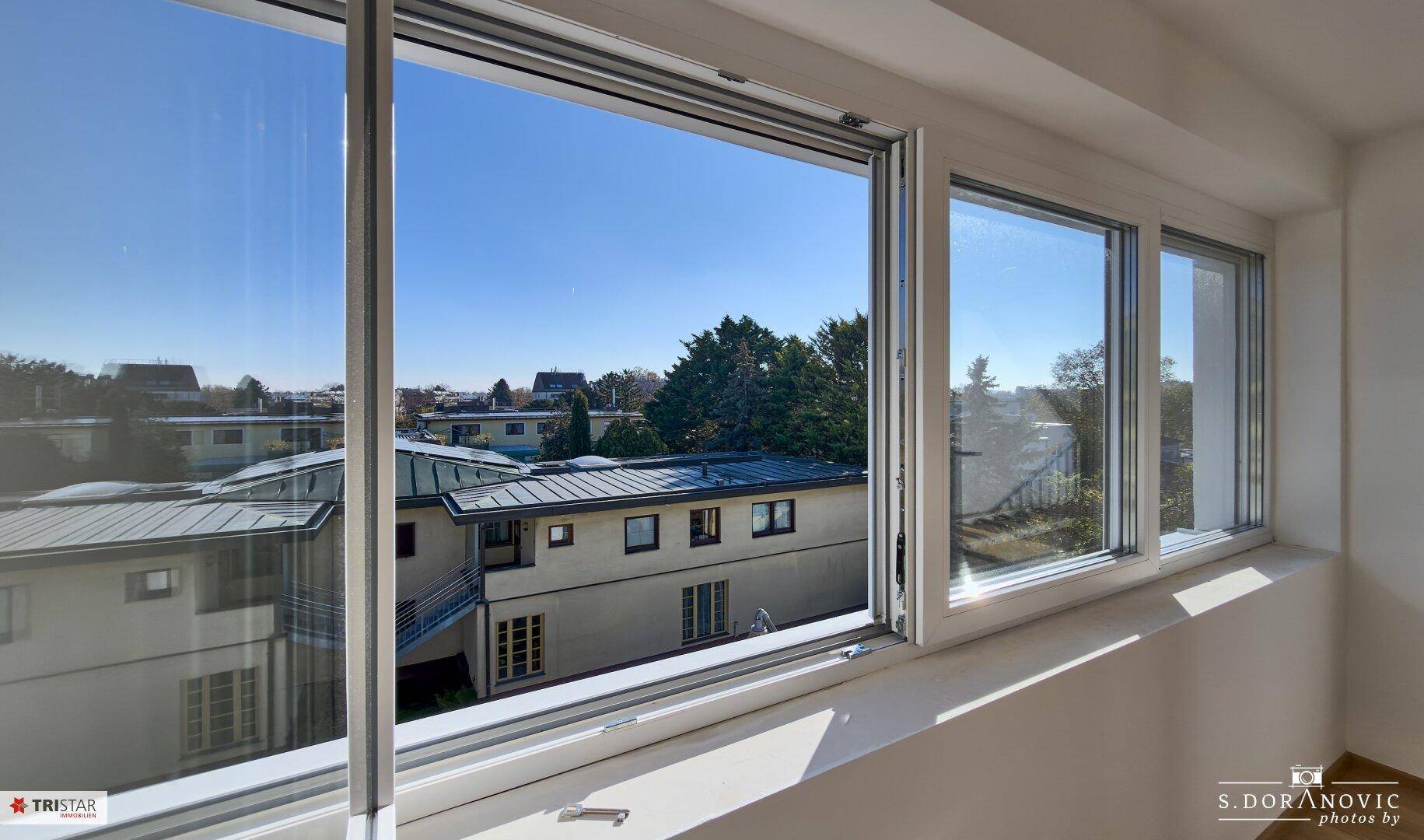 Große Fenster bieten einen weiten Blick auf die umliegende Bebauung und Landschaft.