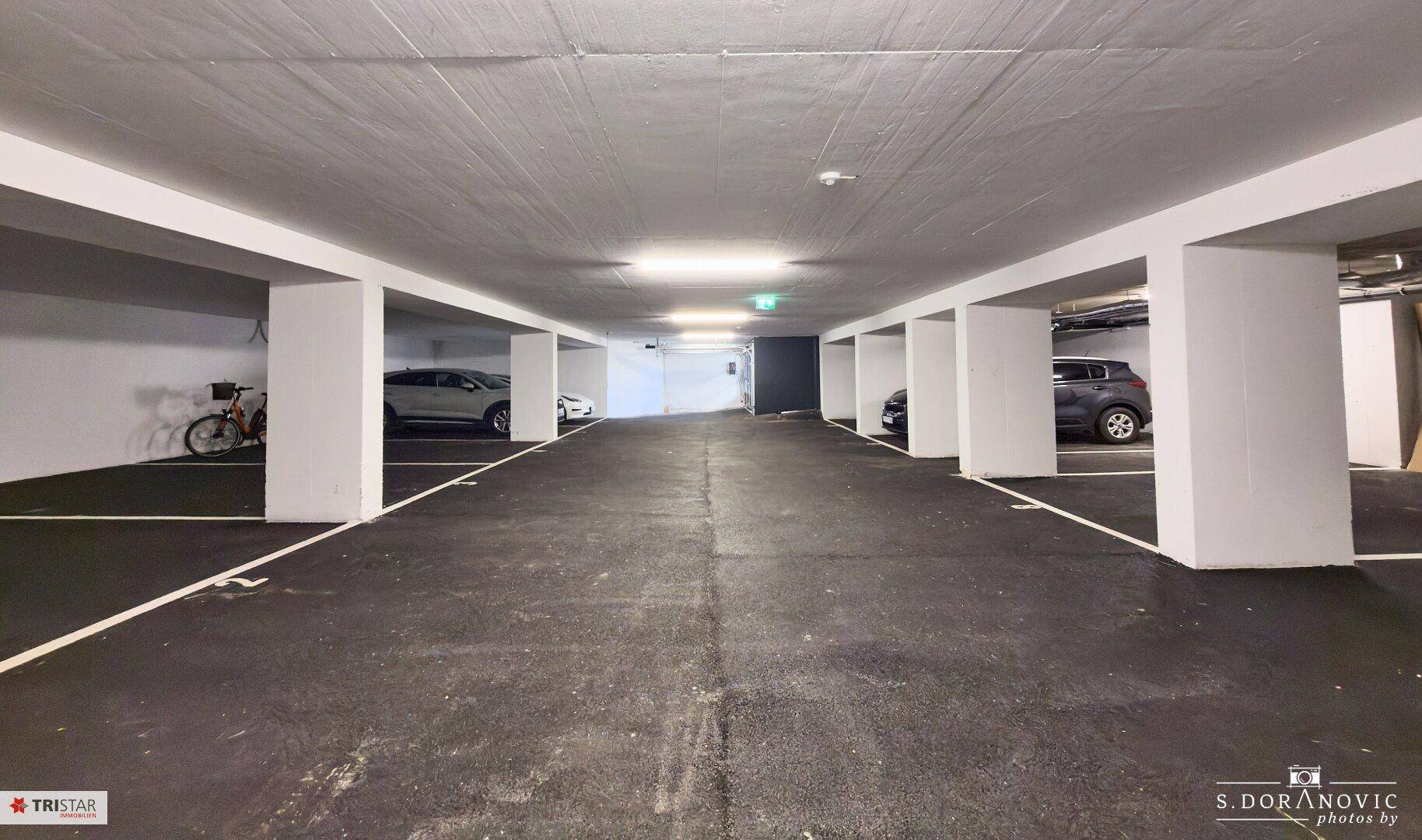 Geräumige Tiefgarage mit markierten Parkplätzen und Säulen.