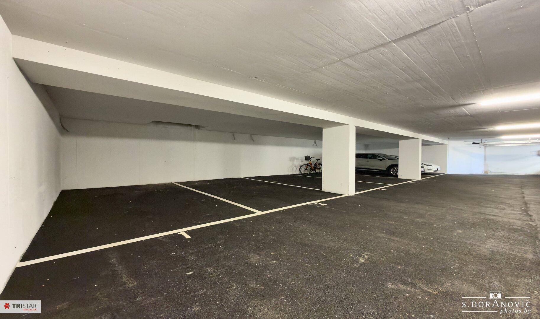 Leere Parkplätze in einer Tiefgarage mit klaren Markierungen.