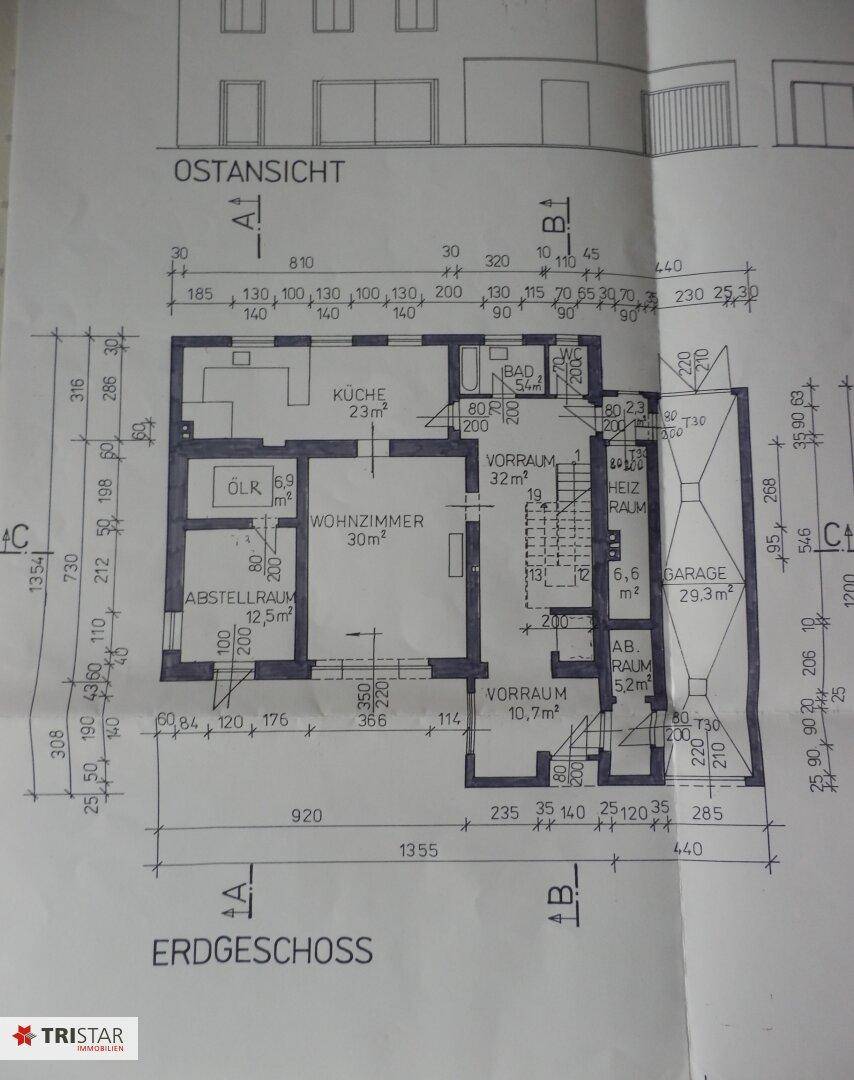 Grundriss des Erdgeschosses mit Wohnzimmer, Küche, Bad und Garage.