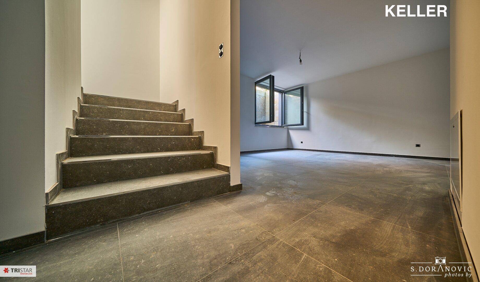 Geräumiger Kellerraum mit Fliesenboden und einer Treppe, die in die oberen Etagen führt.