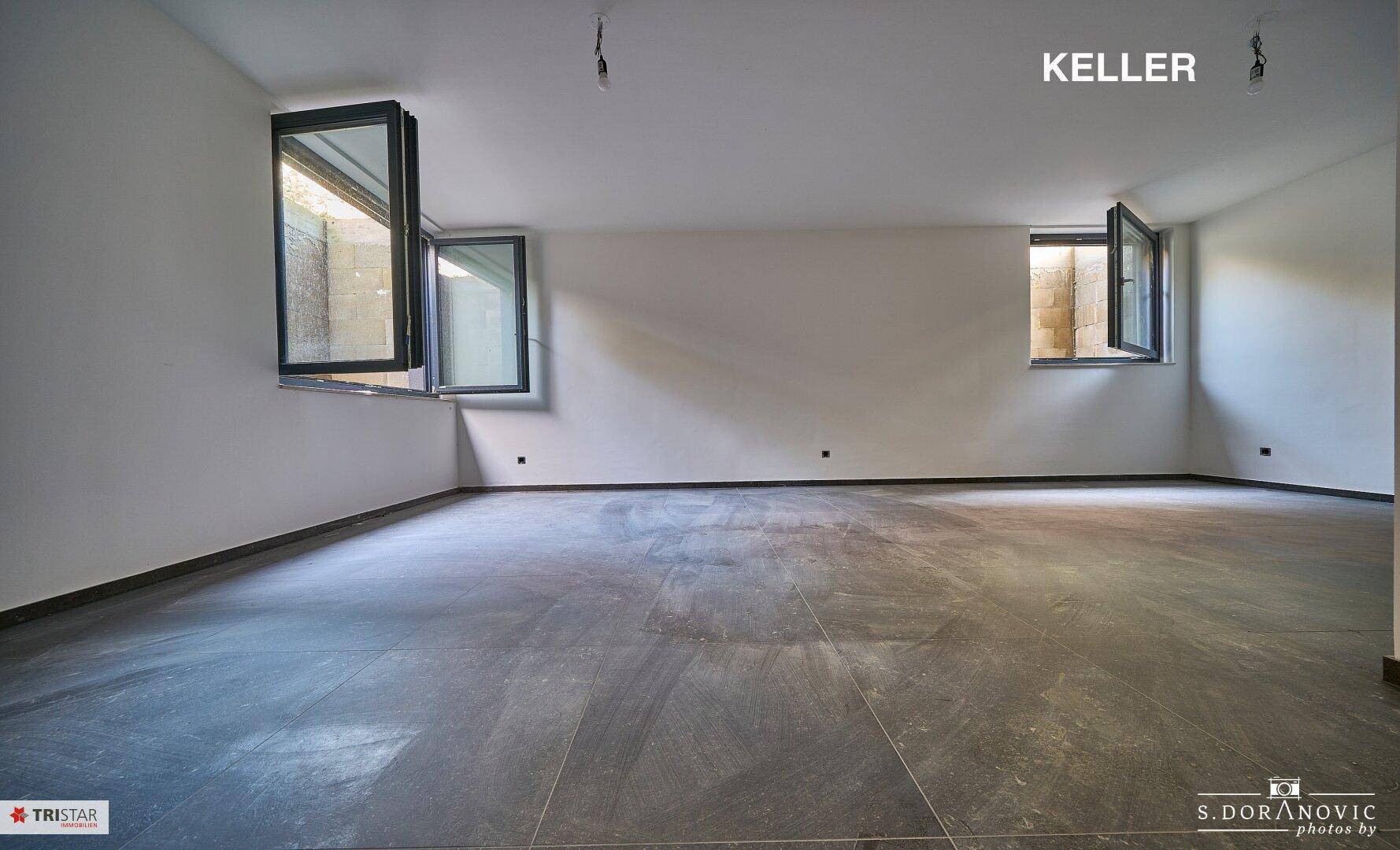 Heller Kellerraum mit großen Fenstern und Fliesenboden, vielseitig nutzbar.