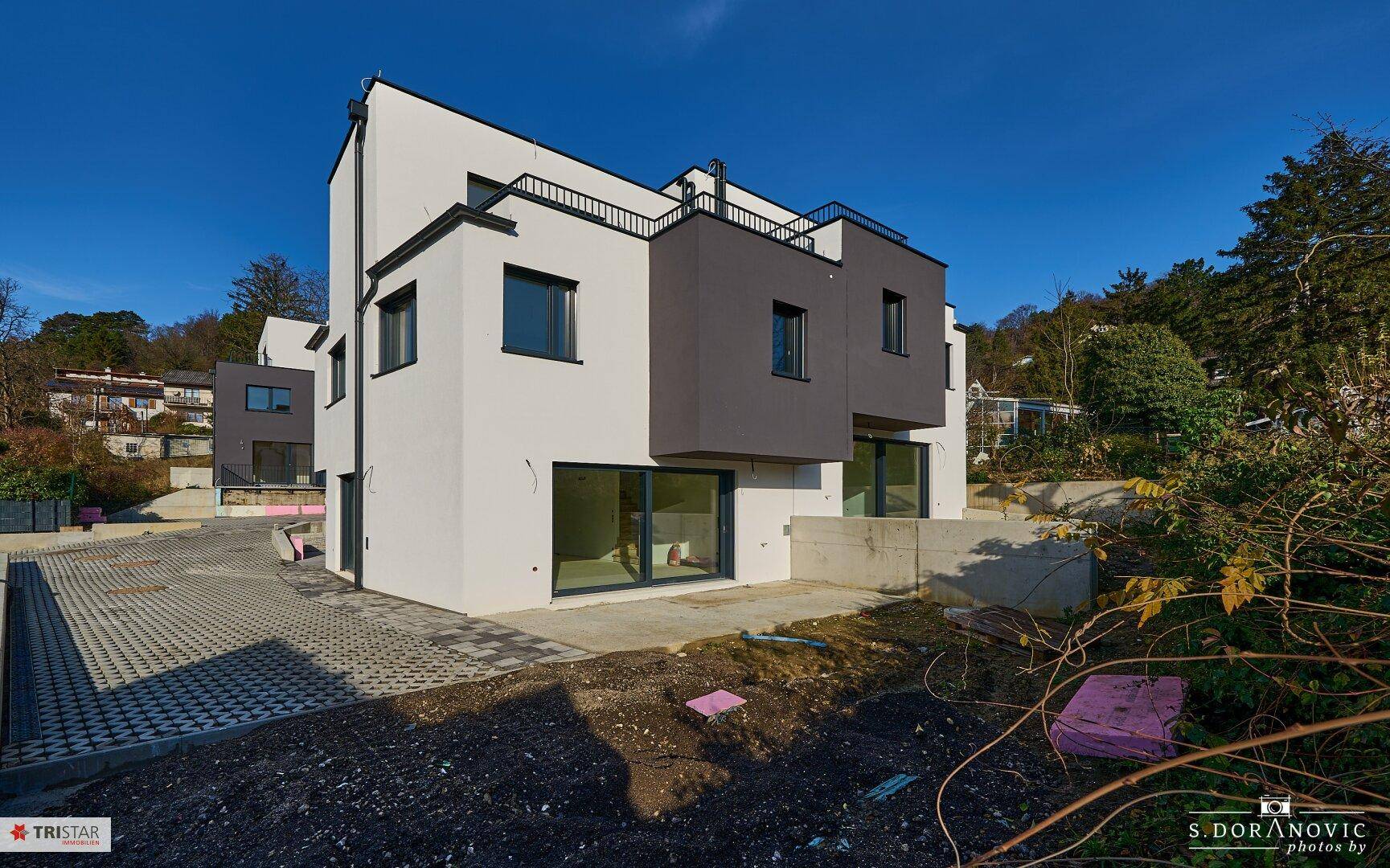 Moderne Doppelhaushälfte mit klaren Linien und großen Fensterfronten in ruhiger Lage.