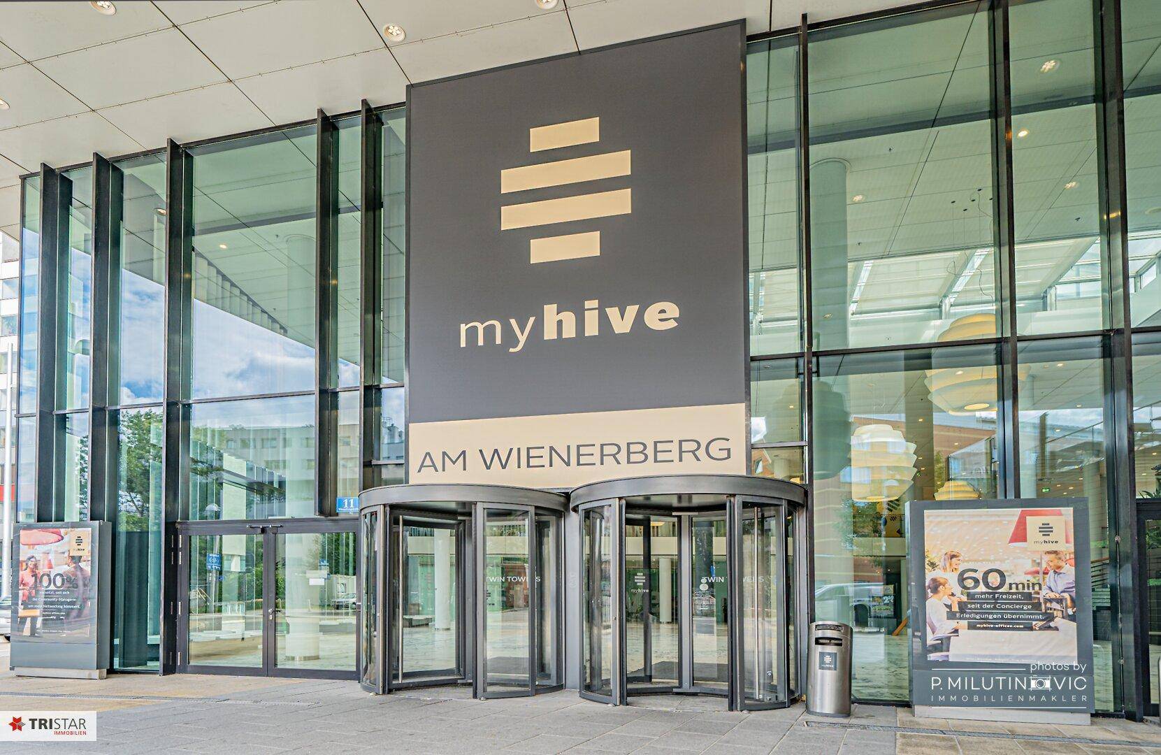 Moderner Eingangsbereich des Gebäudes "myhive AM WIENERBERG" mit Drehtüren.