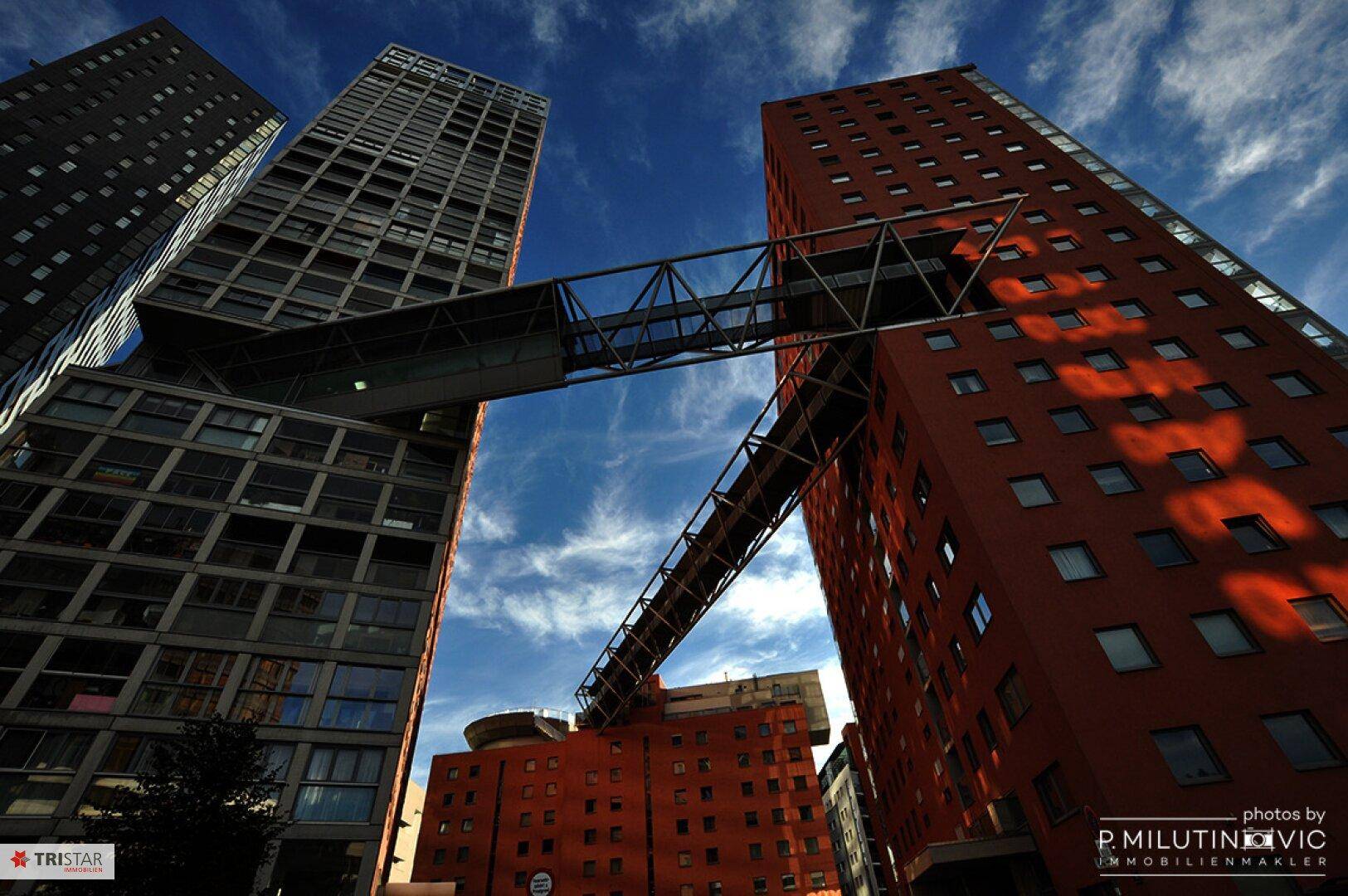 Beeindruckende moderne Gebäude mit architektonisch interessanten Verbindungsbrücken unter blauem Himmel.