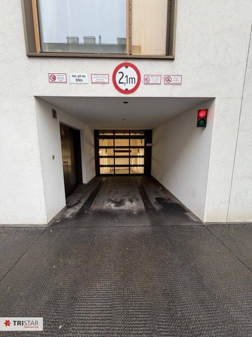 Einfahrt zu einer Tiefgarage mit Höhenbegrenzung von 2,1 Metern und Ampelsystem.