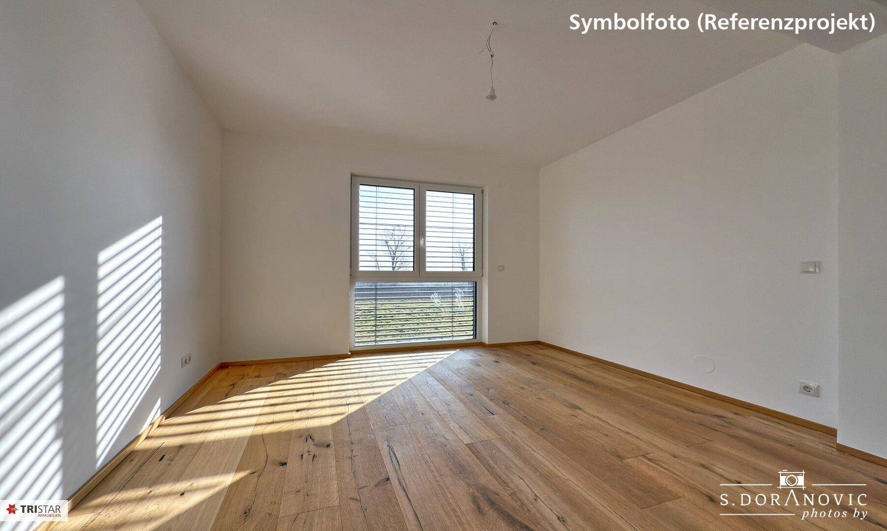 Geräumiges Schlafzimmer mit Holzboden und Fenster, das viel natürliches Licht hereinlässt.