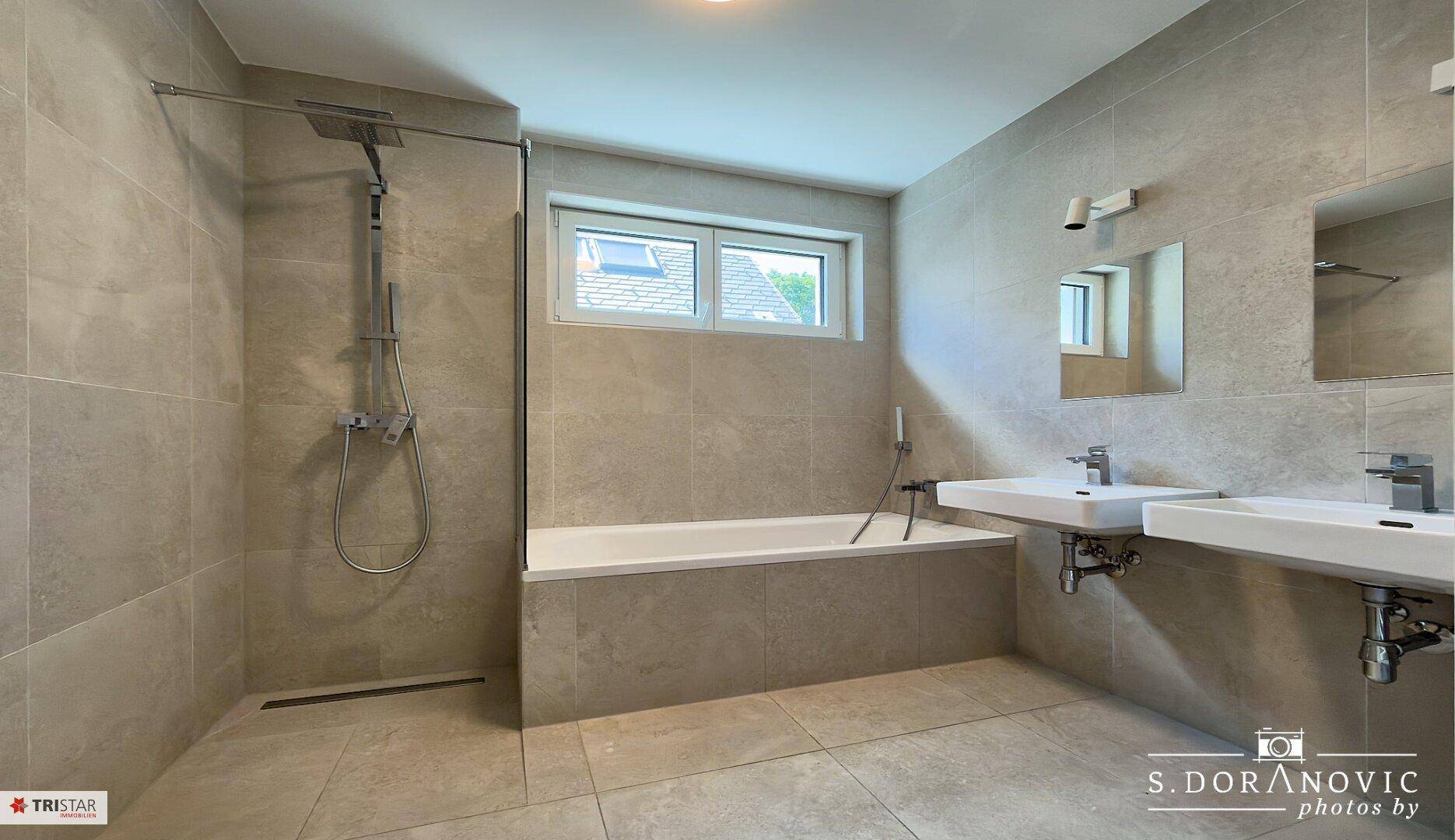 Geräumiges Badezimmer mit Badewanne, begehbarer Dusche und doppelten Waschbecken.