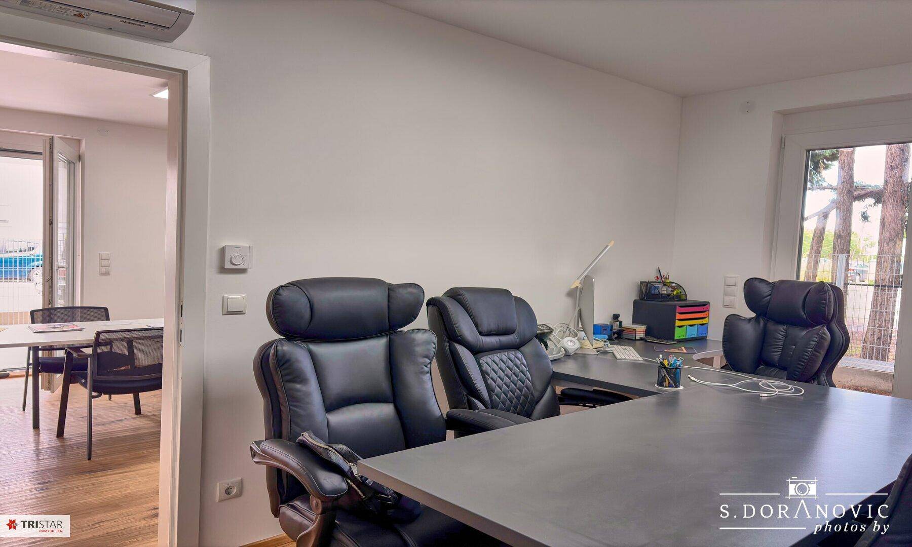 Arbeitsbereich mit bequemen Bürostühlen und Blick auf den Außenbereich.